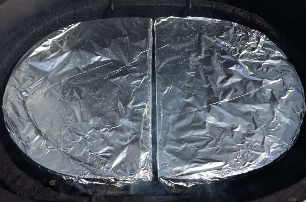 Position the drip pan racks and ceramic d plates over the coals and wood. We highly recommend covering the d plates in foil for easy cleaning. Also, be conscious of their position to make sure there is an even gap around in the center.