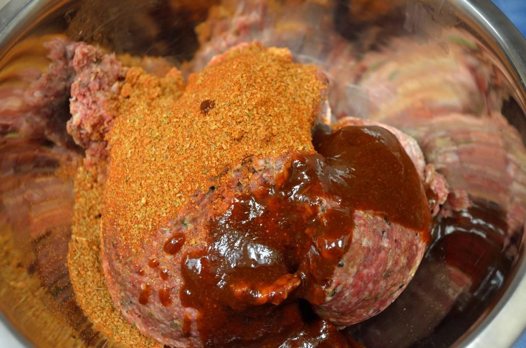 Start with your favorite meatball recipe - just hold whatever salt is recommended. Add a tablespoon of your favorite BBQ rub and two tablespoons of your favorite BBQ sauce per pound of meat. We used 4lbs here. 