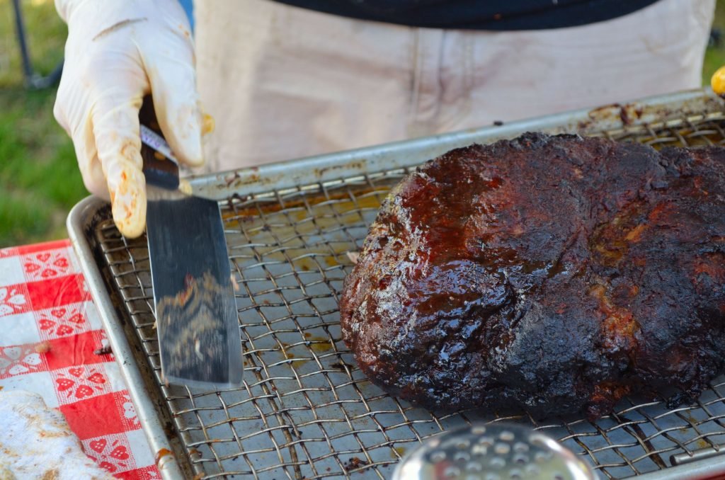 Here is one of 3 Pork shoulders Chef Andrew smoked.  He is getting ready to cut off the "money muscle" on the end