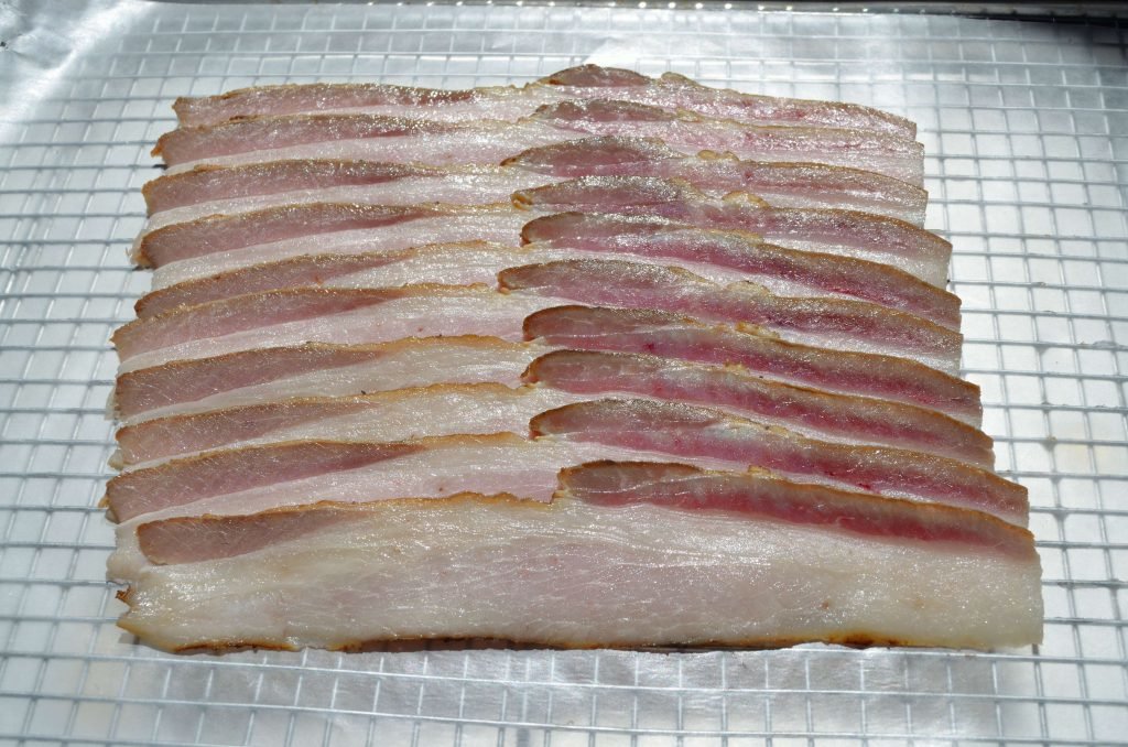 Once the bacon slab is cold slice away- a meat slicer is a helpful tool for this!