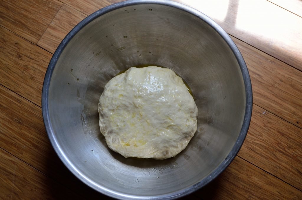 Shape into a ball and put into a bowl greased with the olive oil- coat all sides of the ball and let it rest in a warm place for about an hour.