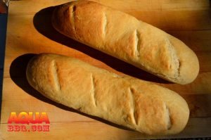 Baked bread sitting on a wooden cutting board