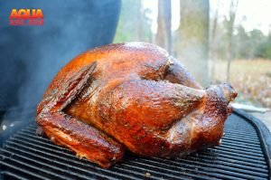 A turkey being smoked on a Primo Grill