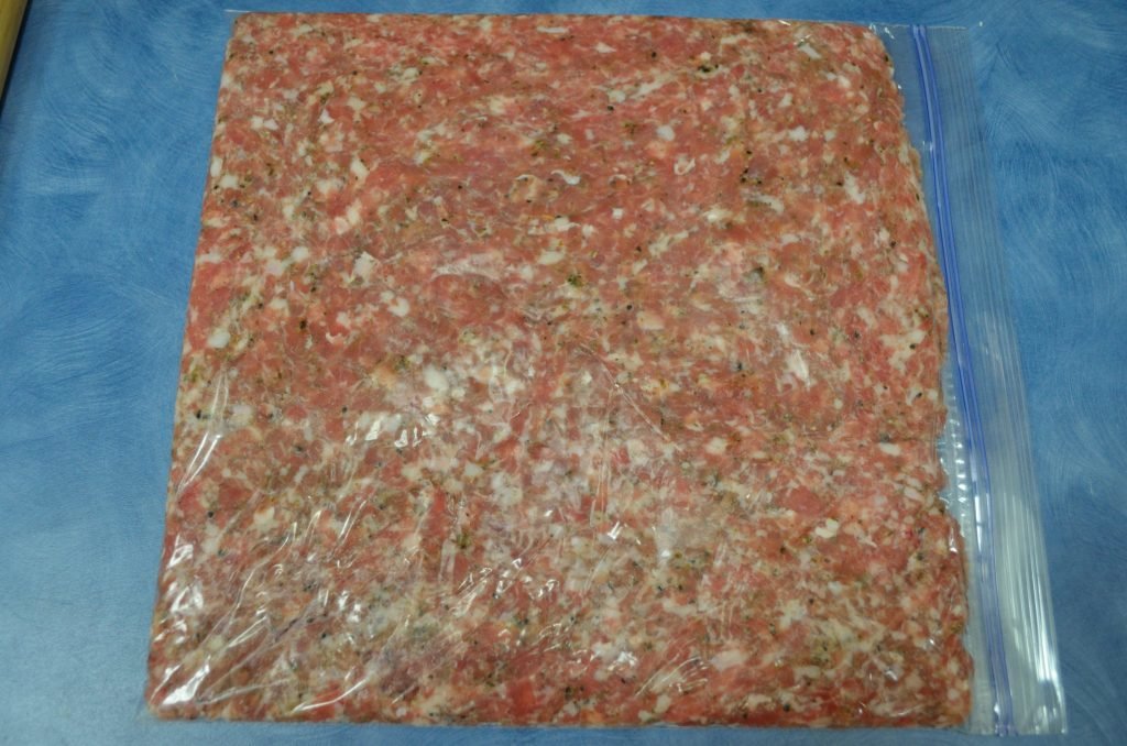 Next, stuff a gallon freezer bag with 1 1/2 to 2 lbs of sausage and flatten into an even layer.  We used sage sausage.