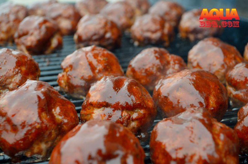 A bunch of meatballs being barbecued