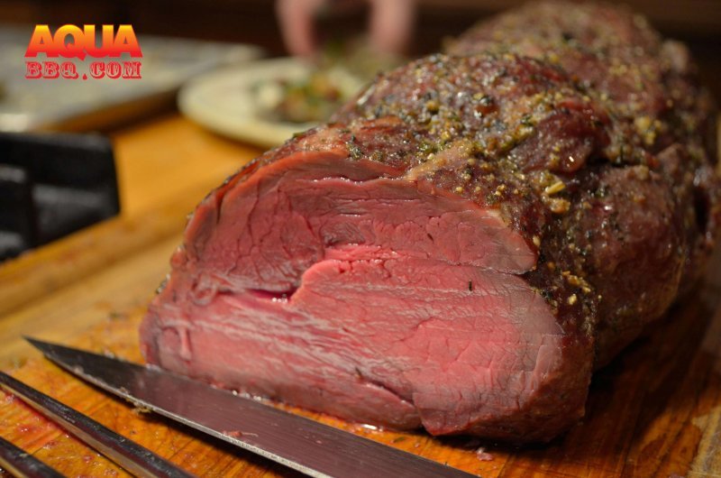 A large prime rib on a cutting board with knives