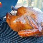 A large turkey roasting on a grill