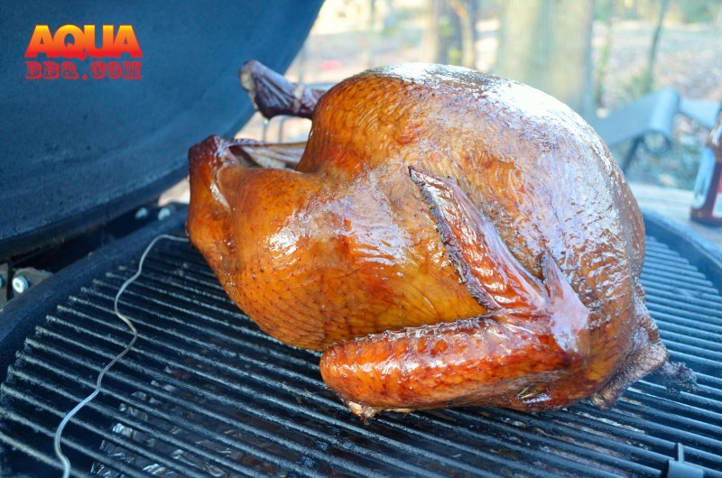 A large turkey roasting on a grill